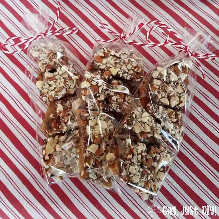 Homemade english toffee packaged in cellophane bags with red and white paper background