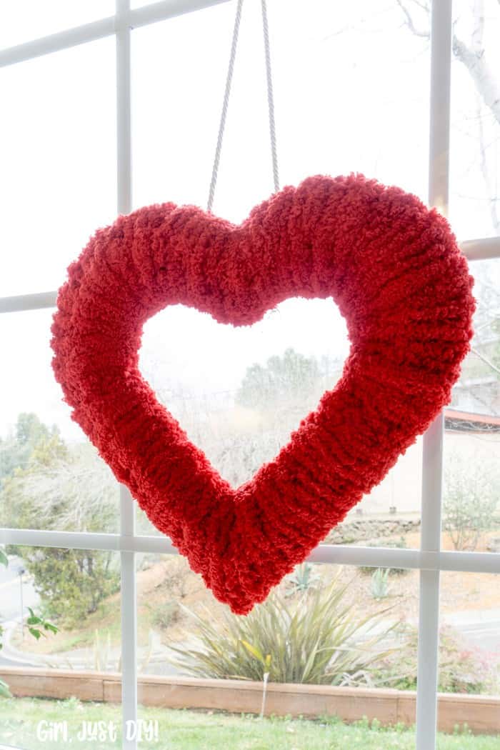 Closeup of Double-sided fluffy valentine wreath hung in window.