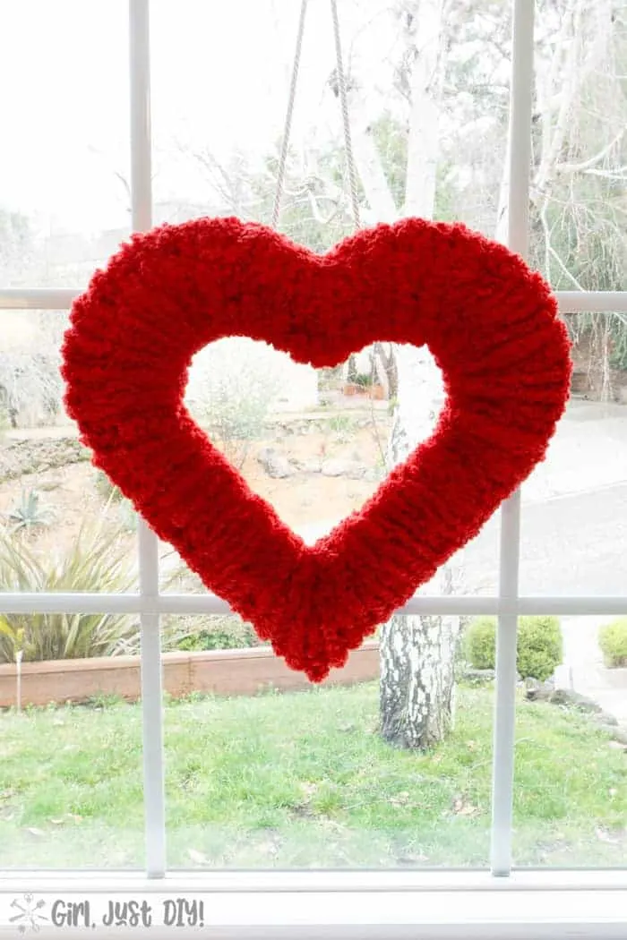 Double-sided fluffy valentine wreath hung in window.