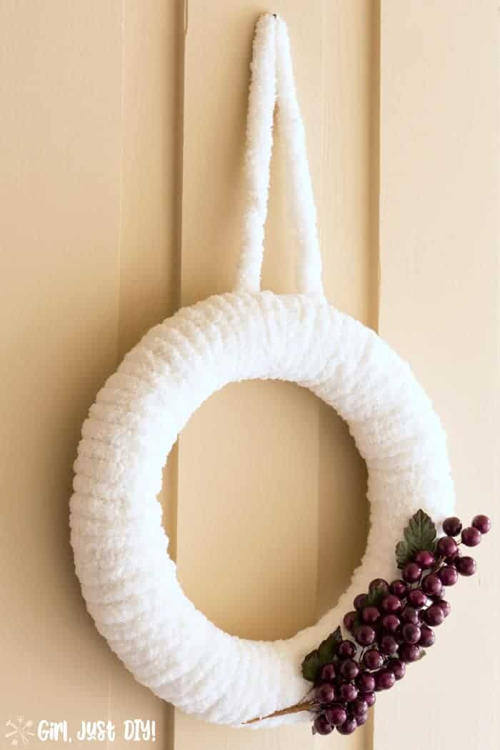 Completed fluffy winter wreath with grape clusters.