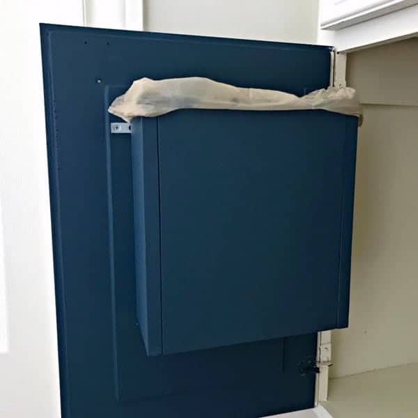 Bathroom trash can built inside vanity cabinet door.