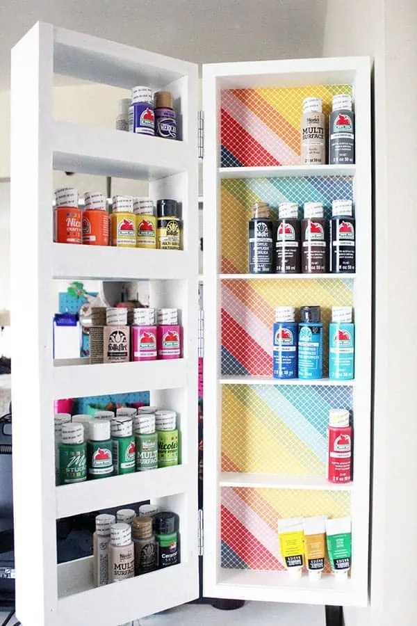 Fold out shelves filled with colorful craft paint.