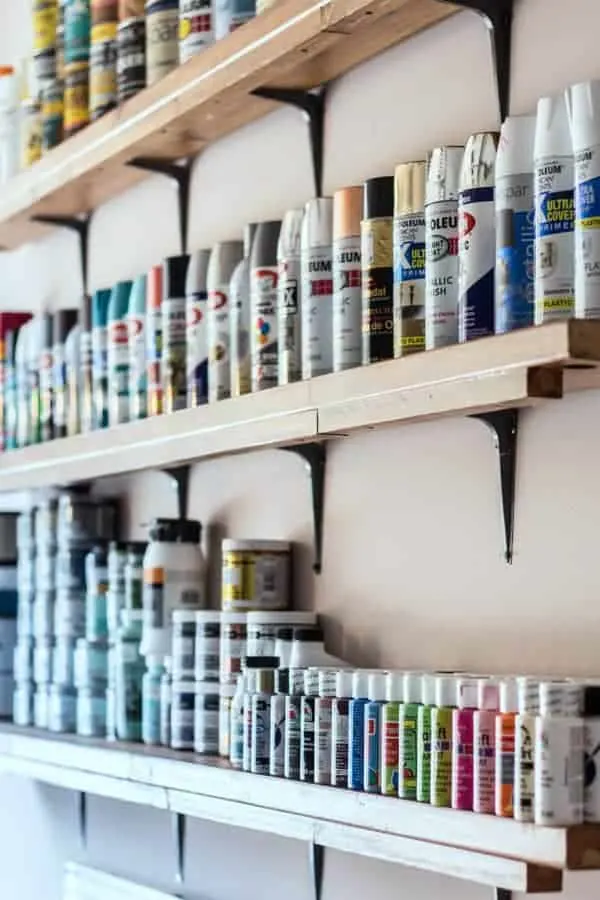 Narrow shelves lined with colorful paint cans.