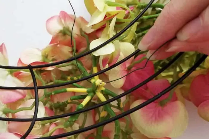 Inserting wire under and around silk blossoms.