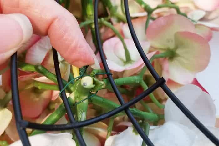 Bending twisted wire on hydrangea wreath underside.
