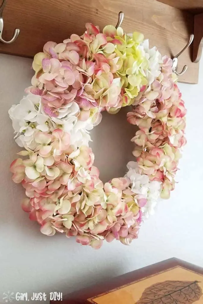 Faux Hydrangea wreath hanging on hook over buffet.