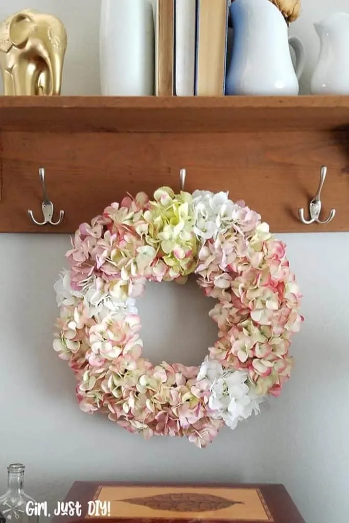 Faux Hydrangea wreath hanging on coat rack hook.