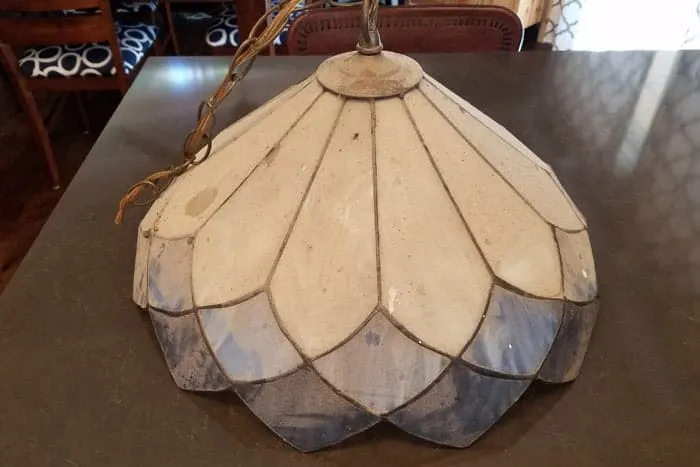 Dirty stained glass lampshade on kitchen counter.