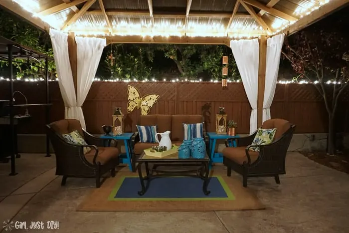 View of diy patio gazebo at night with lights on.