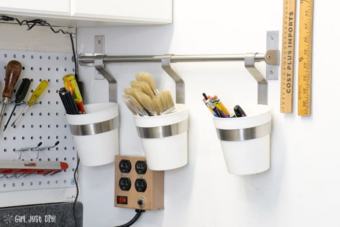 Buckets hanging on wall next to installed pegboard wall.