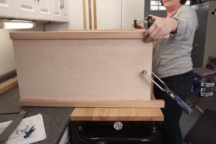 Cabinet build on side with clamps holding legs together.
