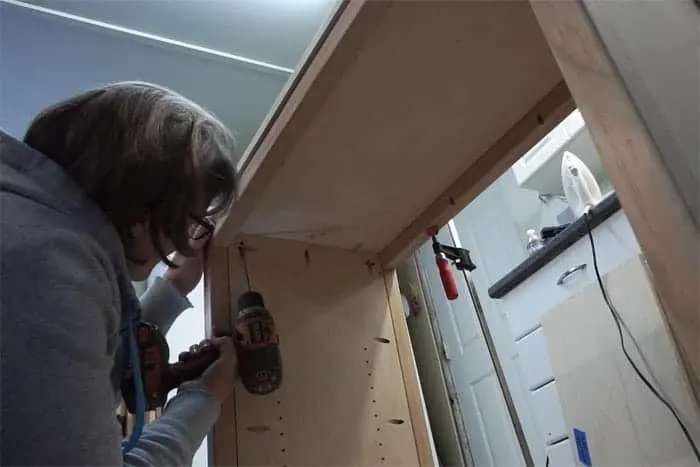 Attaching top to base of chevron storage cabinet.