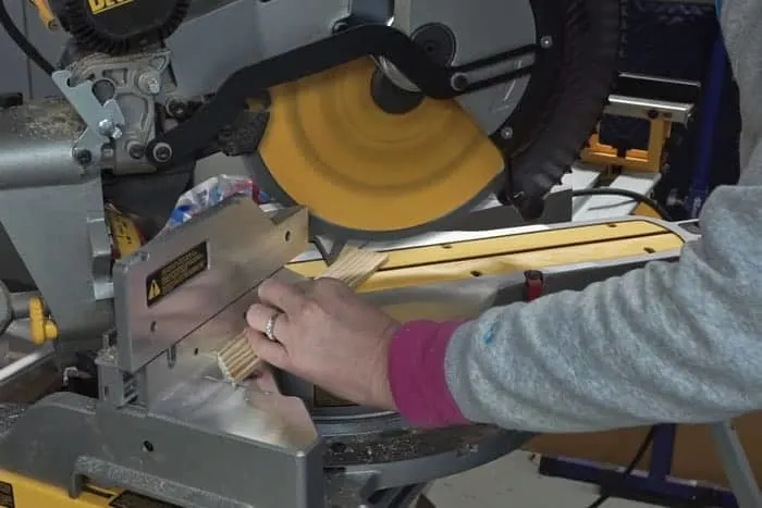 Miter saw cutting trim pieces for cabinet build.