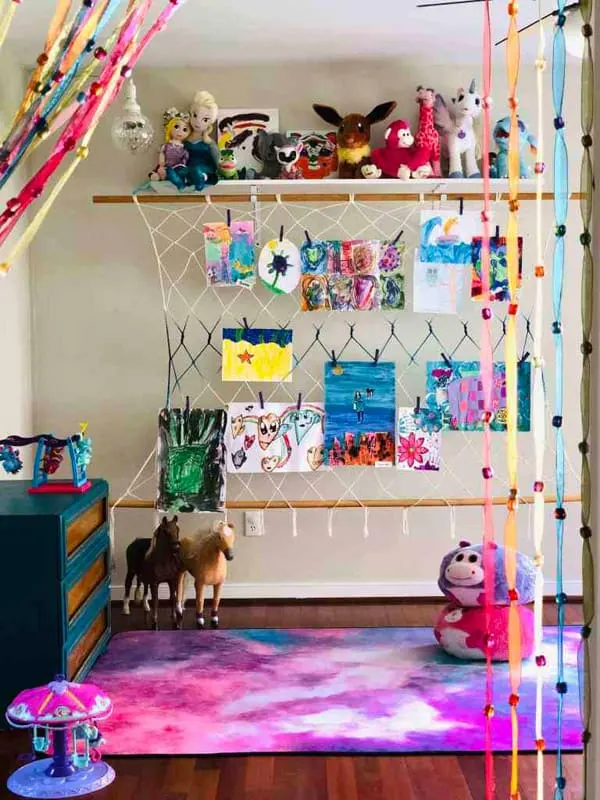 Colorful artwork display in colorful bedroom hung with child's art.