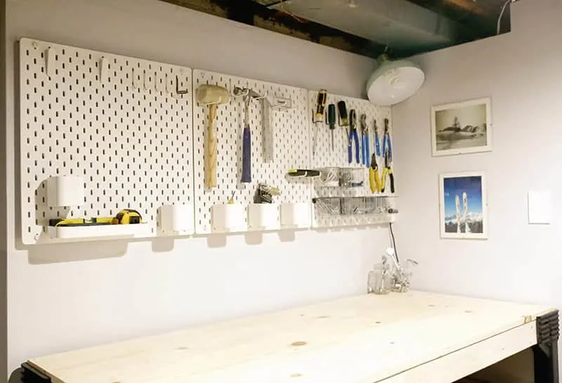 Pegboard wall system hung in basement workshop.