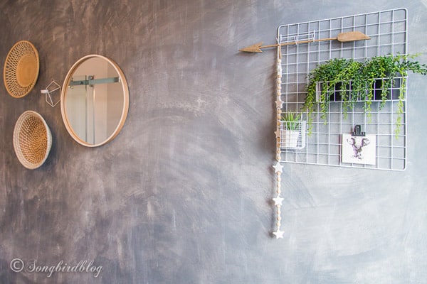 Faux painted concrete wall hung with baskets.