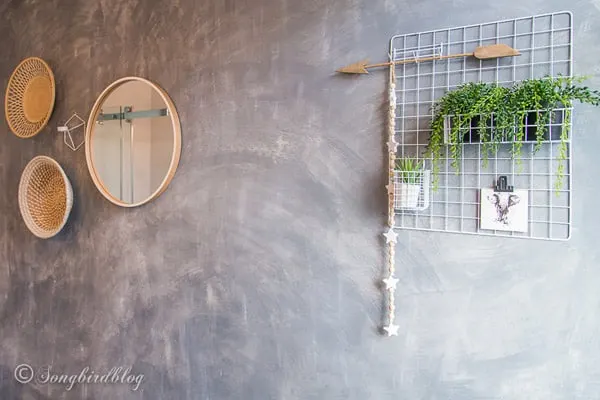 Faux painted concrete wall hung with baskets.