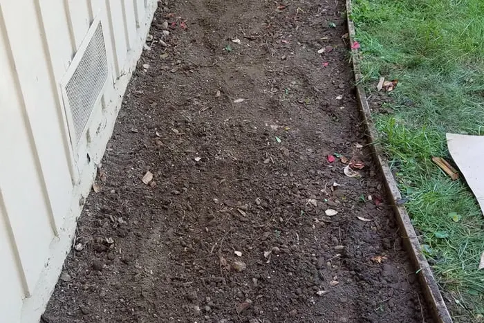 Dirt in the cleared out flower bed ready for plantings