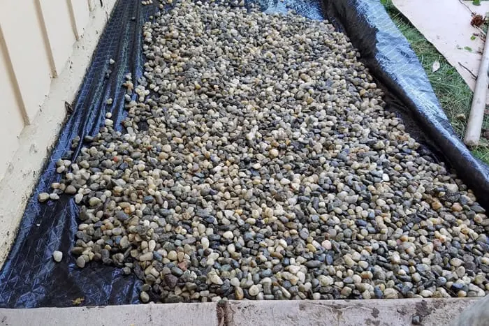 Rock poured over weed block in new flower bed.