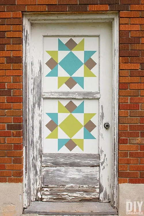 Barn Quilt painted squares in windows of old wood door.