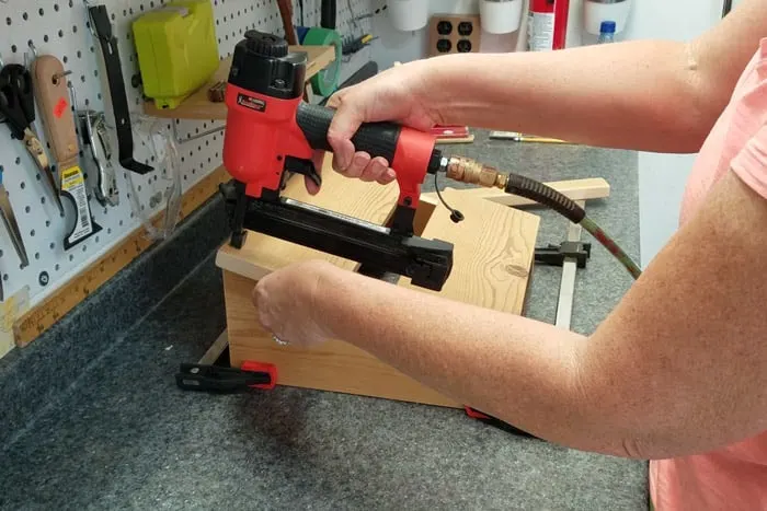 Attaching final top board to footrest legs with brad nailer.