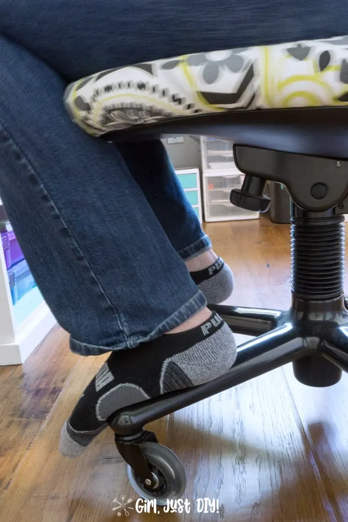 Office chair showing socked feet resting on the chair legs