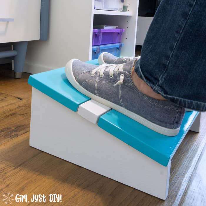 Closeup of blue and white diy footrest with blue tennis shoed feet resting on it.