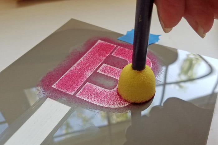 Raspberry Red paint being stenciled onto letter B with foam stippler.