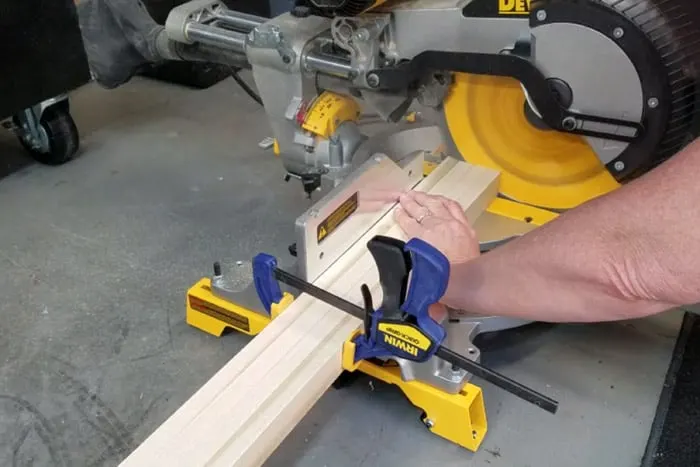 Four boards clamped together getting trimmed at miter saw.