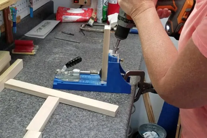 Drilling pocket holes into 1x2 board using a Kreg Jig.