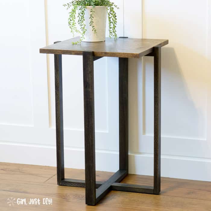 DIY Modern End Table with green plant in a white pot against a white cabinet.