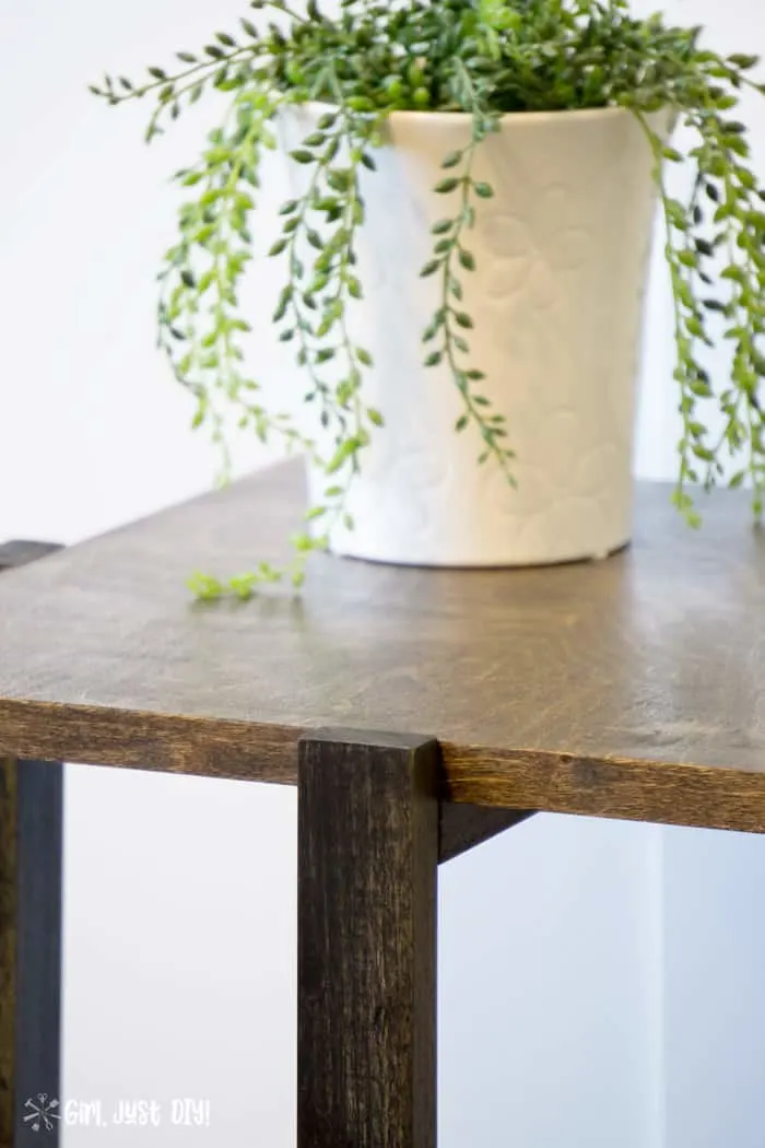 Closeup of DIY modern end table showing walnut top contrasting with ebony base.