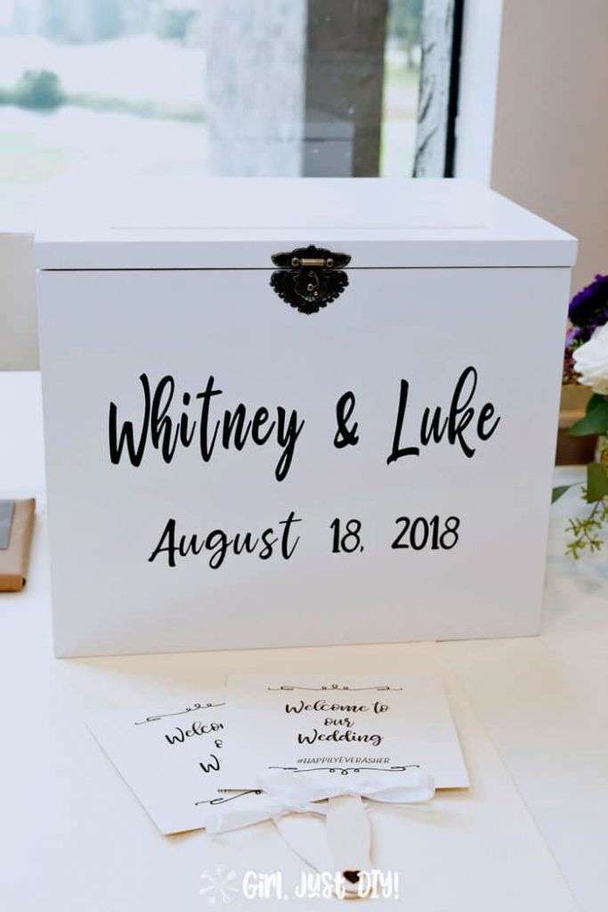 Gift table at reception showing wedding card box by a window.