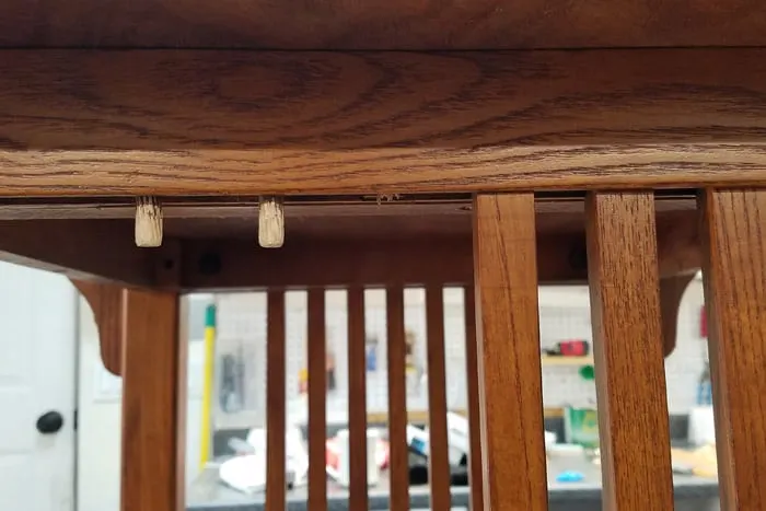 Dowels sticking out next to mission style table rails.