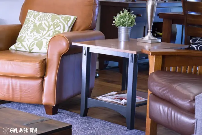 Wide shot of diy industrial end table makeover between two side chairs.