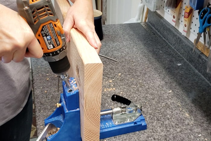 Drilling pocket holes into 2x4 plant stand shelf.