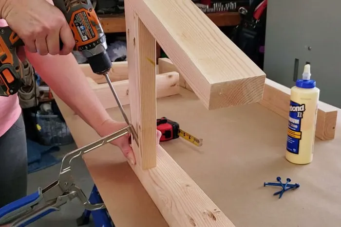 Attaching 2x4 legs parts together with pocket hole screws using a drill.