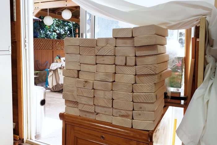 Stack of 56 2x4s on top of cabinet in garage.