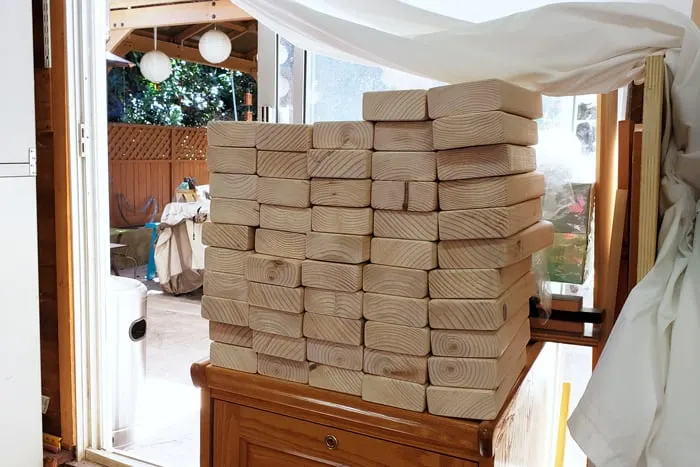 Stack of 56 2x4s on top of cabinet in garage.