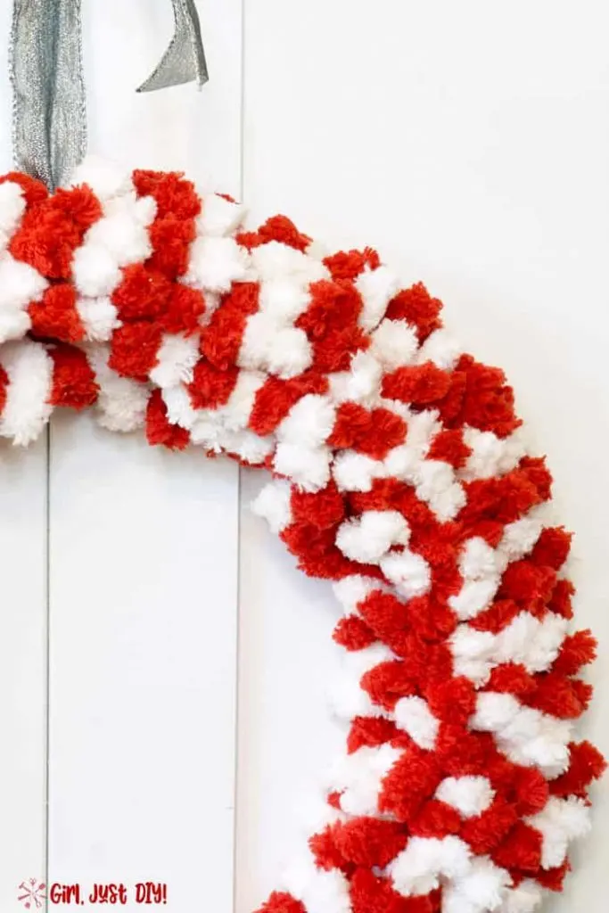 Side picture of Red and white fluffy wreath with silver ribbon on top.