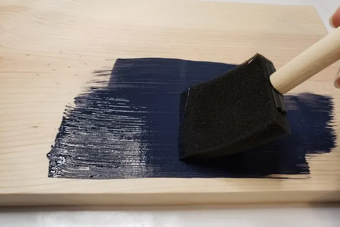 Dark blue paint applied to pine board with foam paint brush.