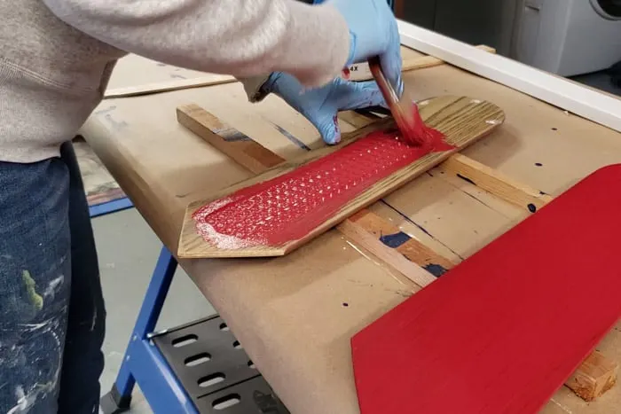 Painting fan blades with red exterior paint.