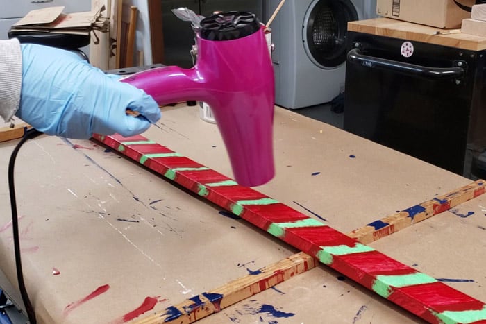 Speeding up the drying time using a blow dryer to dry painted pole.