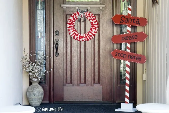 Wide shot of front porch with christmas wreath and santa stop here sign.