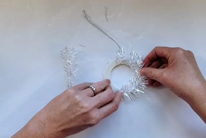 Holding tinsel in place while hot glue dries.