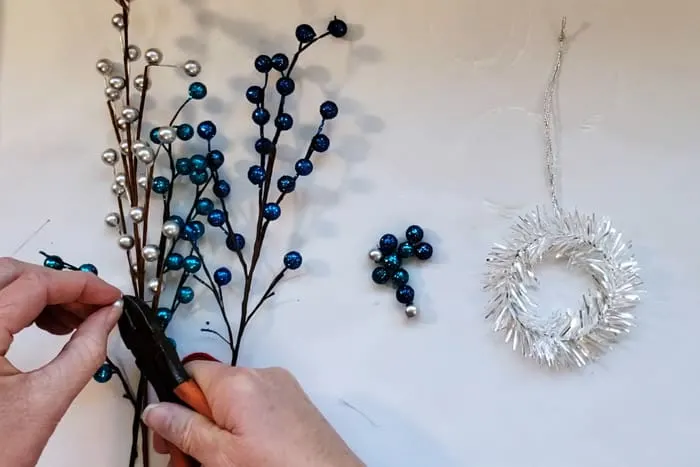 Using wire cutters to cut glittery berries from christmas picks.