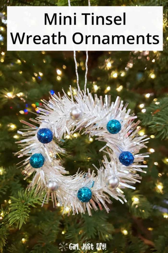 Tinsel Mini Wreath Ornament with blue berries hung on lighted tree.