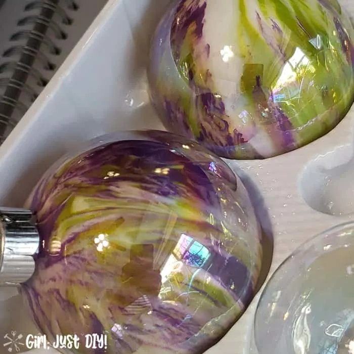 Green, purple and white ornaments in plastic holder.