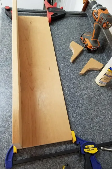 Boards glued and clamped together at right angles to create coat rack.