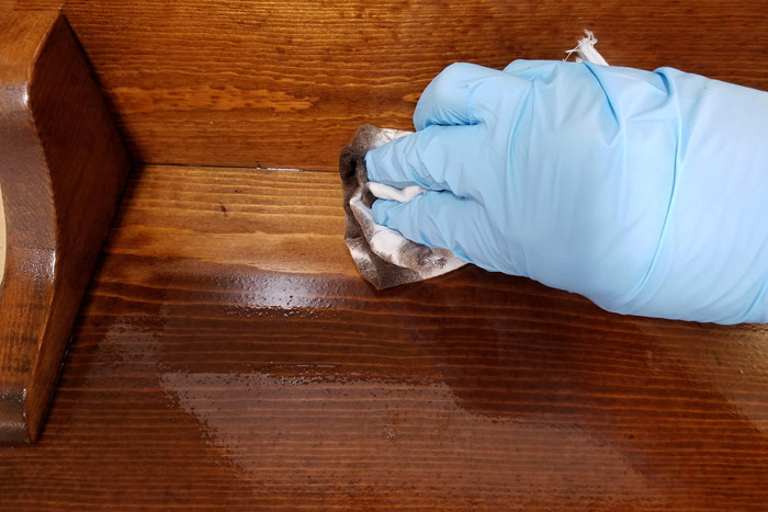 wiping off excess wood stain with an old rag.